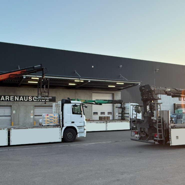 LKW-Flotte mit Ladekran beim Beladen